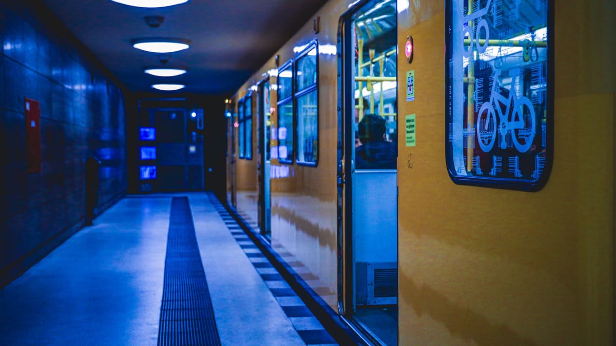 A yellow train at a Berlin subway station, illuminated at night, showcasing metro life.